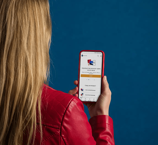 Kobieta trzymająca telefon z otwartą aplikacją banku PKO BP na ekranie